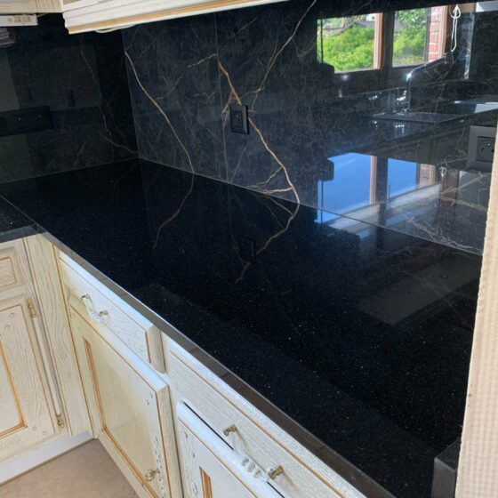 Rossi & Fils à Sclessin : Plan de travail en granit Black Galaxy et crédence en imitation marbre noir dans une cuisine